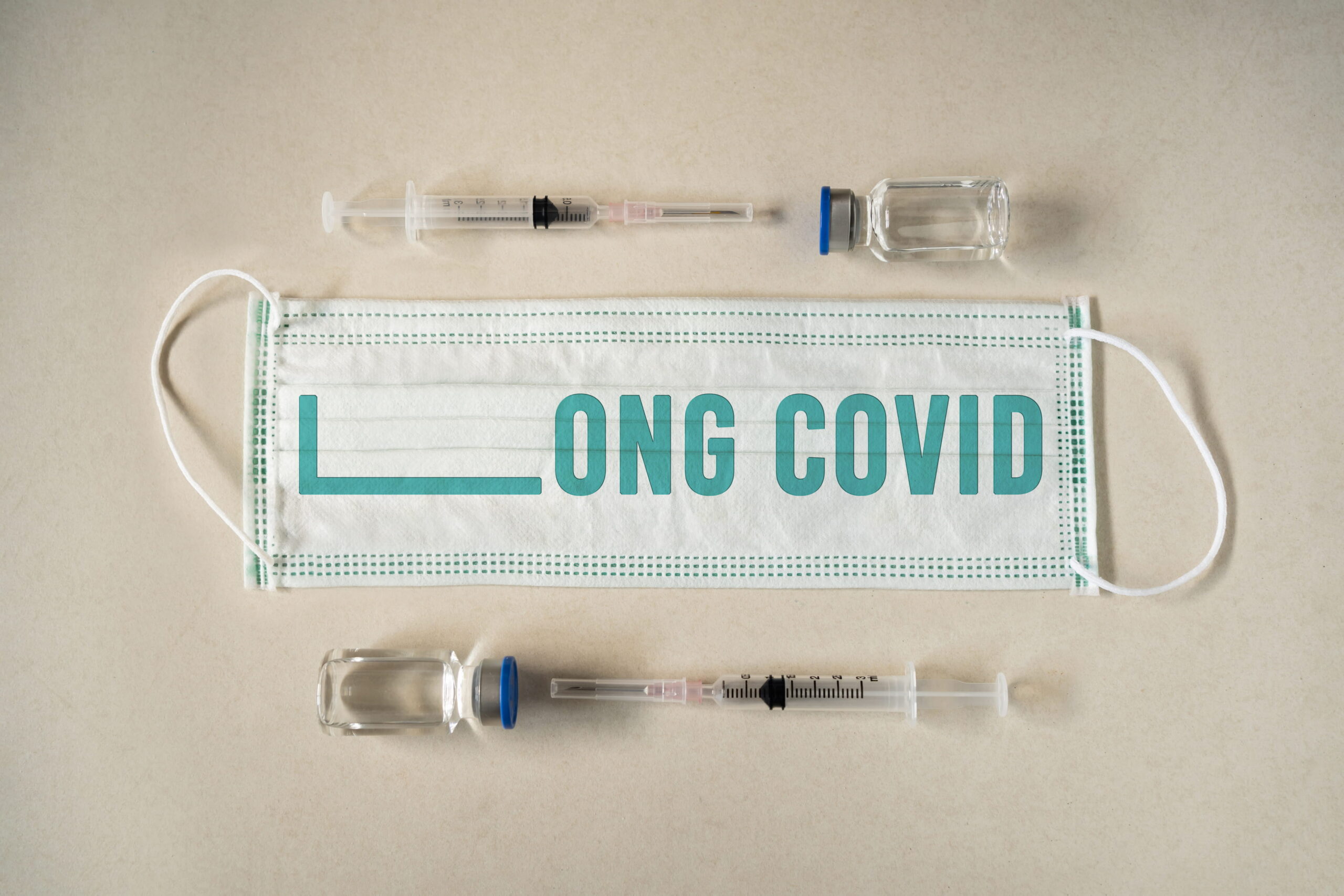 A face mask displaying the words "Long COVID," symbolizing persistent post-viral symptoms like brain fog and fatigue.